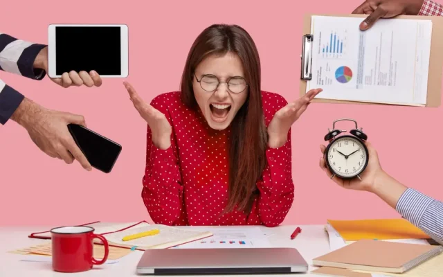 brunette-woman-sitting-desk-surrounded-with-gadgets-papers-1